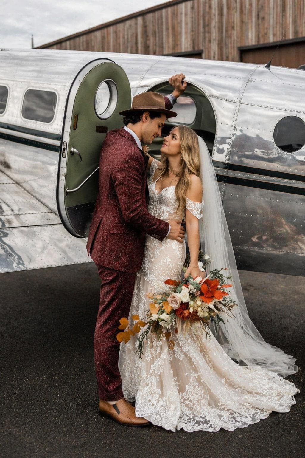 Vintage travel couple portraits of a couple beside a polished vintage aircraft